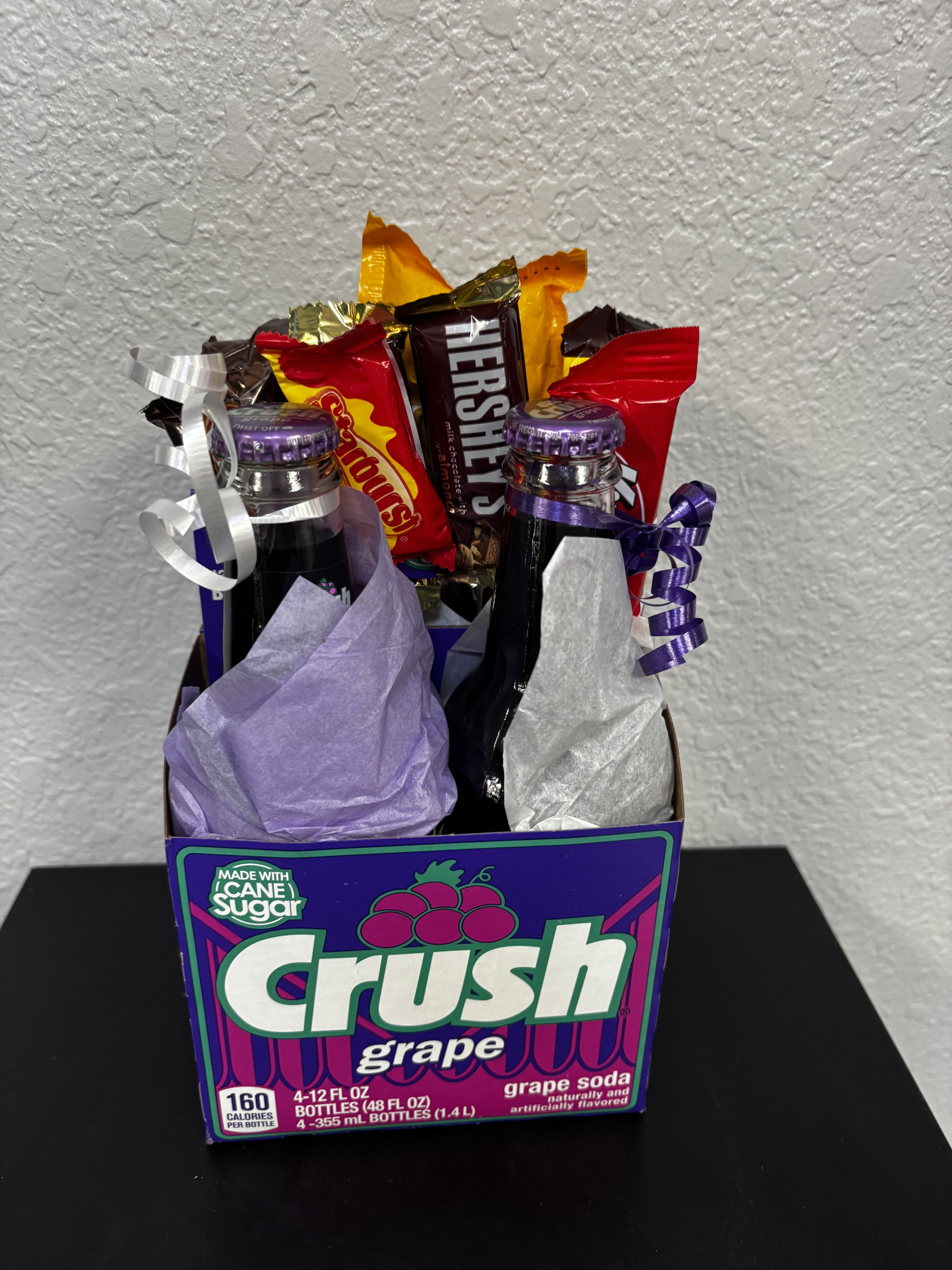 Gift basket with soda bottles and candy bars in a Crush grape box