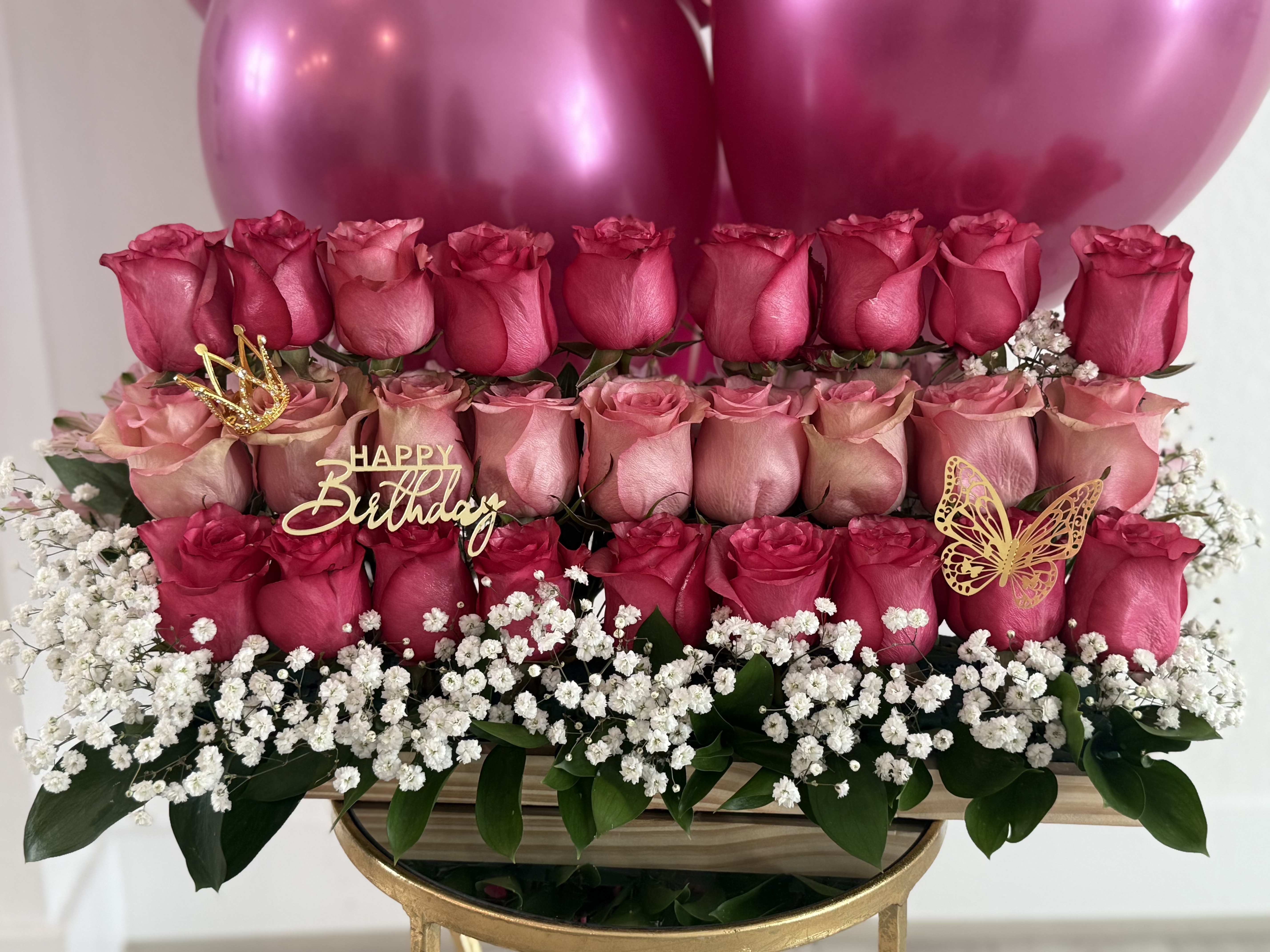 Tiered pink rose arrangement with birthday topper and balloons