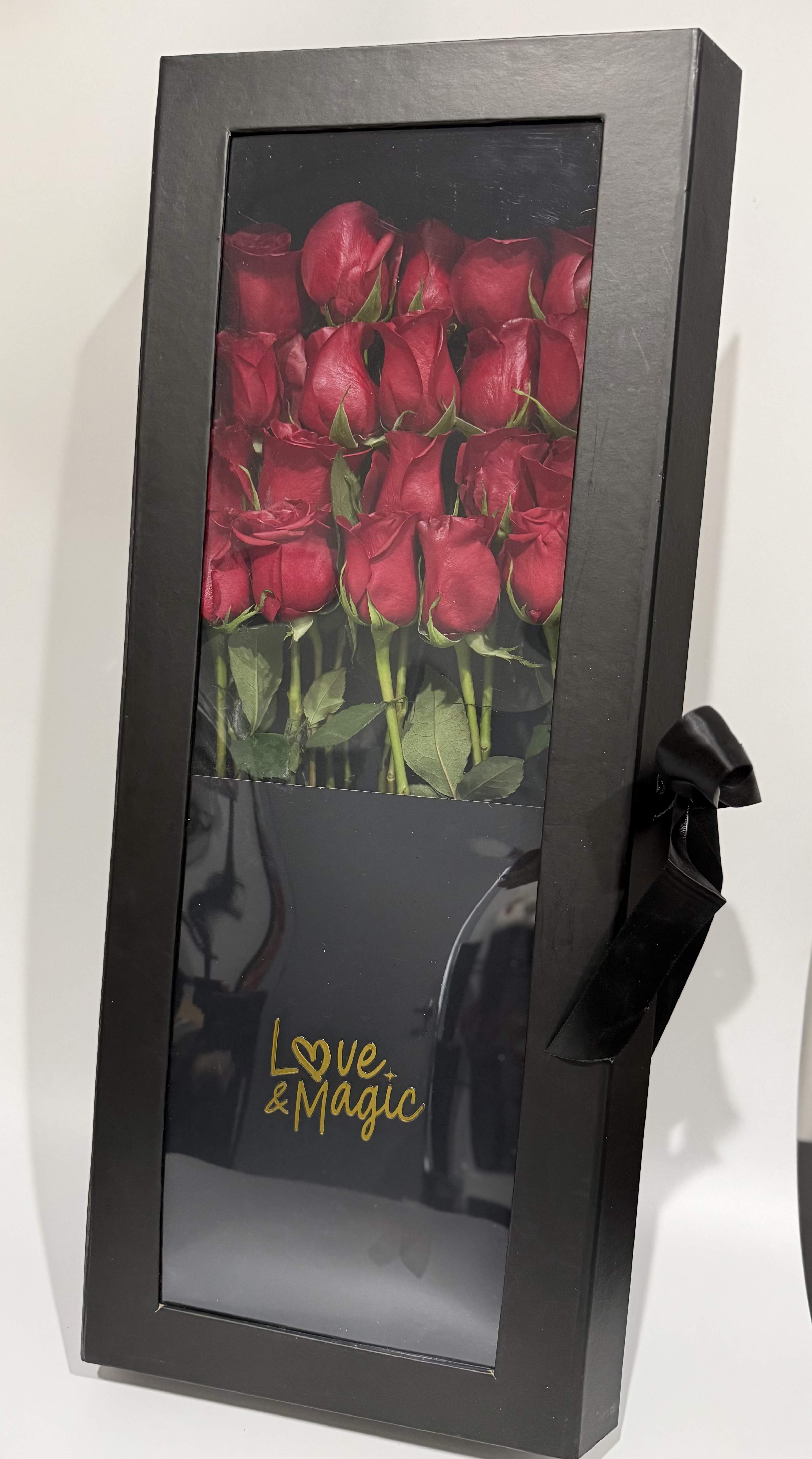 Boxed arrangement of red roses with a black ribbon