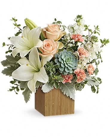 Bouquet of white lilies, peach roses, and pink carnations in a wooden cube vase