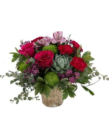 Bouquet of pink and red flowers in a textured vase