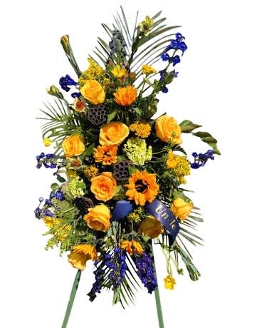 Tall standing floral spray with yellow and orange flowers and blue accents