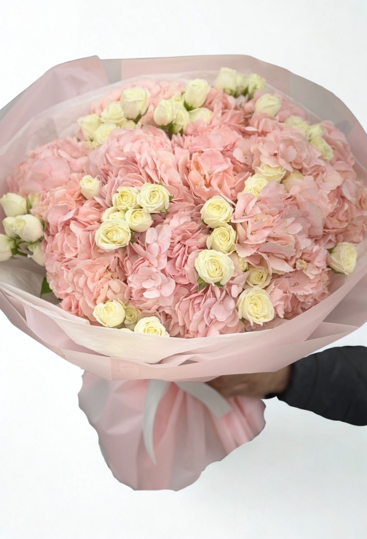 Pink hydrangea and cream rose bouquet wrapped in pale pink paper
