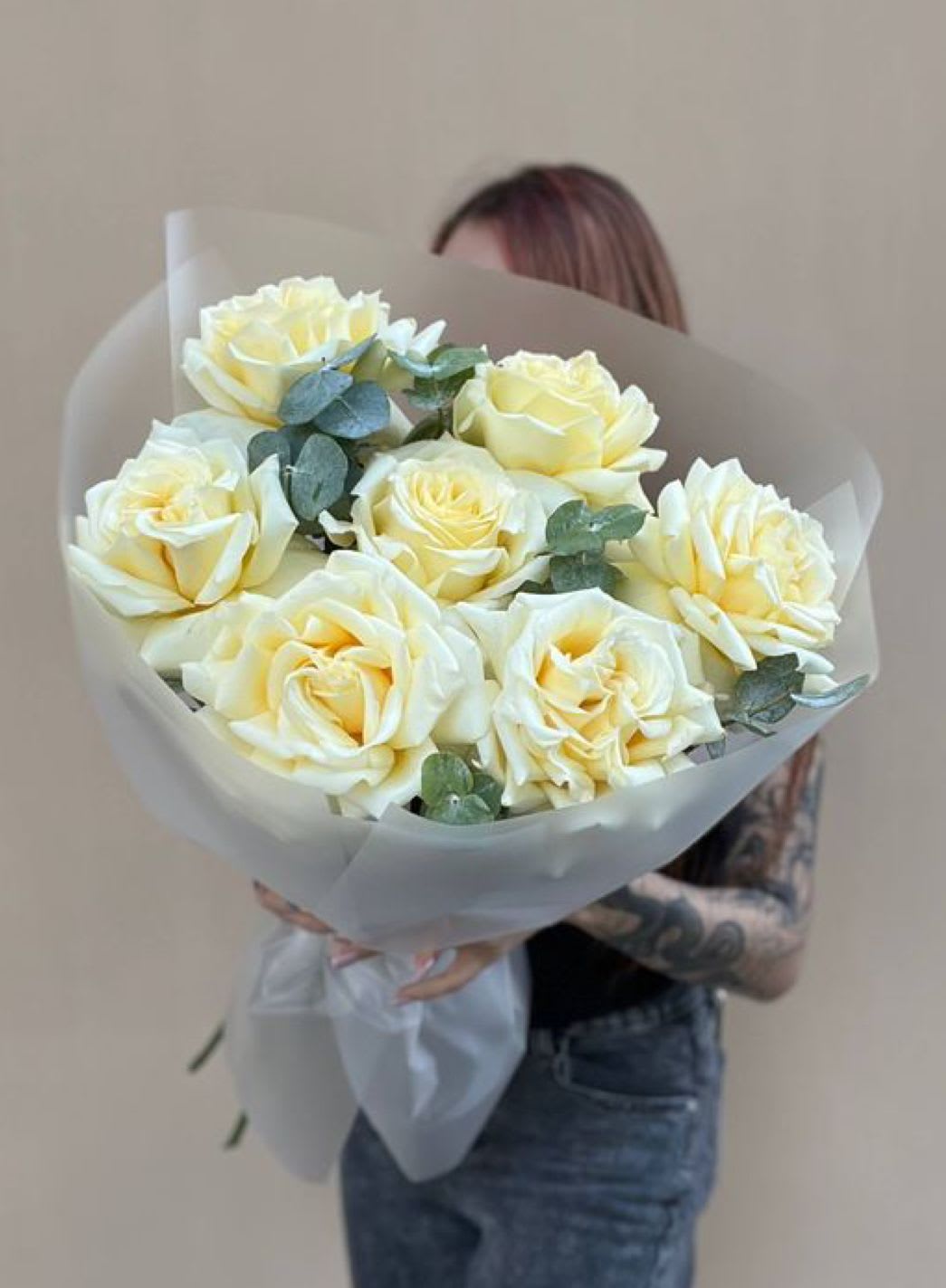 Bouquet of pale yellow roses wrapped in translucent paper