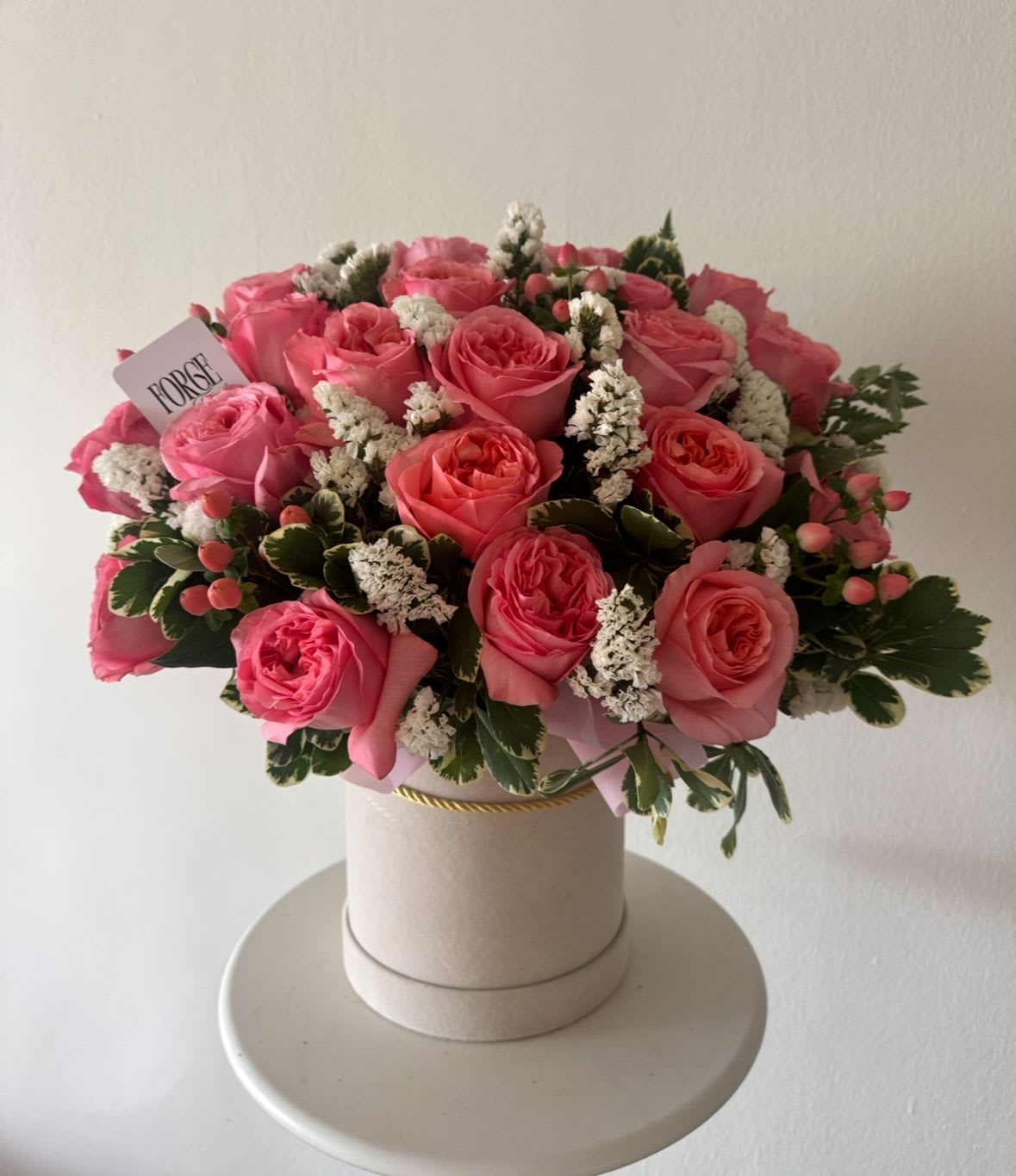 Rosé Garden Hat Box- garden roses, pittosporum,statice - A romantic hat box arrangement featuring premium garden roses in soft shades of pink, complemented by seasonal accent flowers and lush greenery. Designed in an elegant keepsake box, this arrangement is perfect for birthdays, anniversaries, celebrations, or simply letting someone know you’re thinking of them.  Please note: Flower varieties may vary slightly based on seasonal availability while maintaining the overall style, color palette, and value of the arrangement.