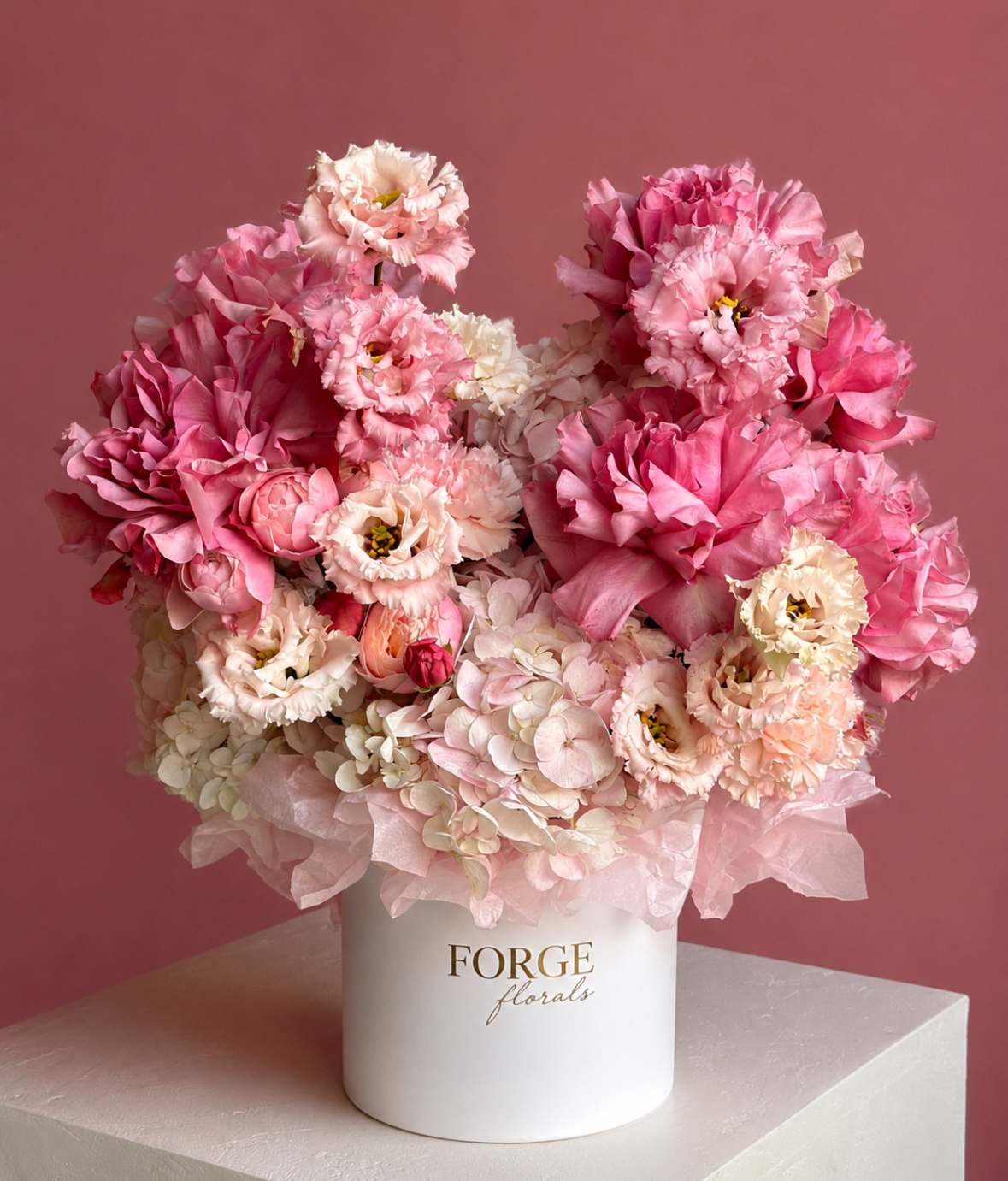 Pink and white floral arrangement in a white hat box