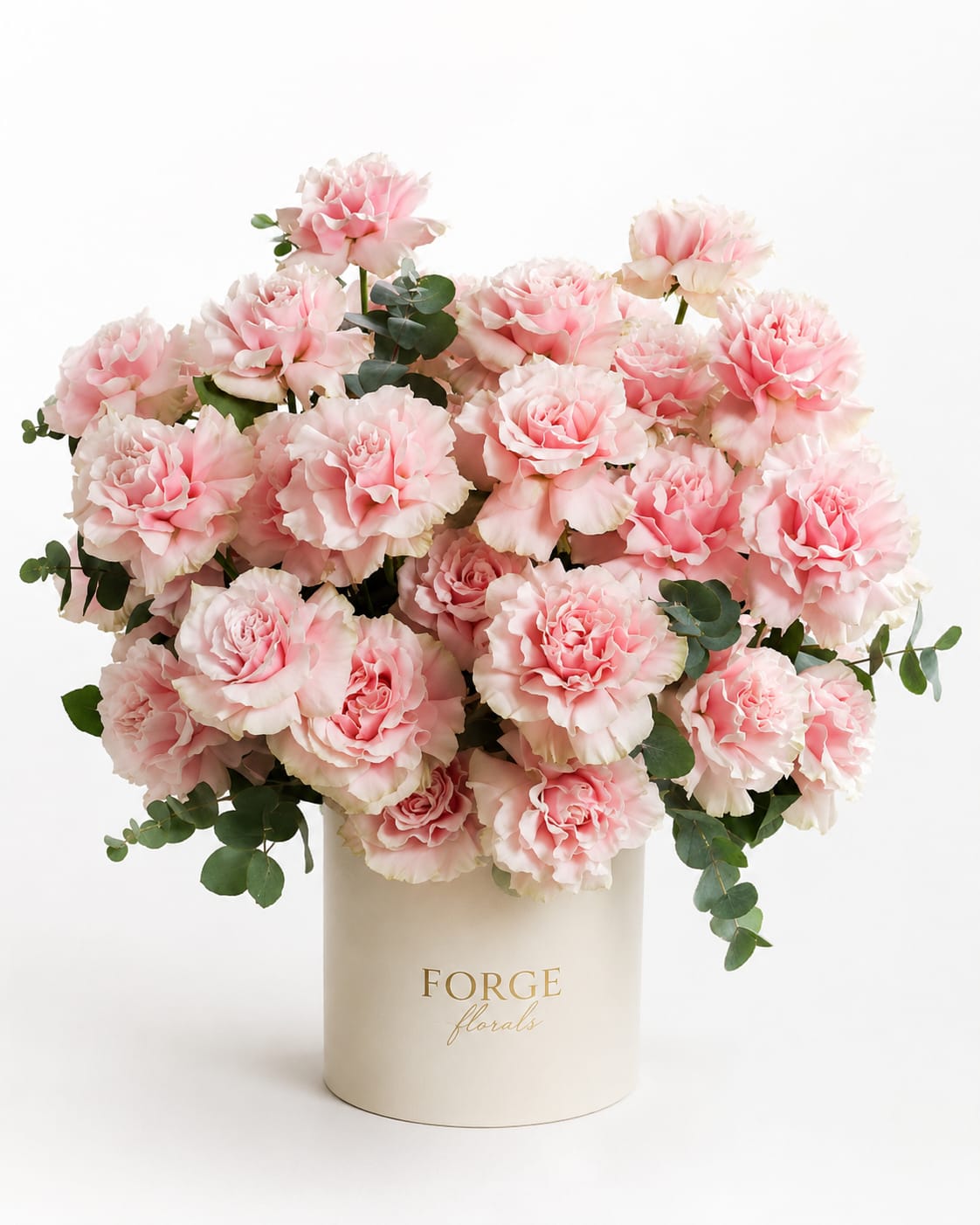 Pink carnations arranged in a cream hat box