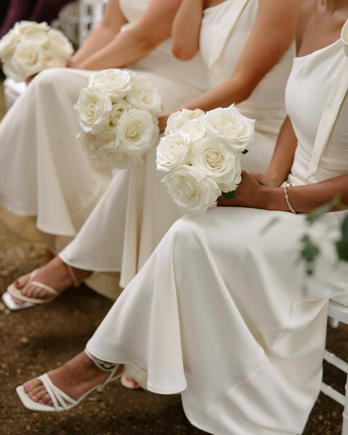 White rose bouquets held by women in white dresses