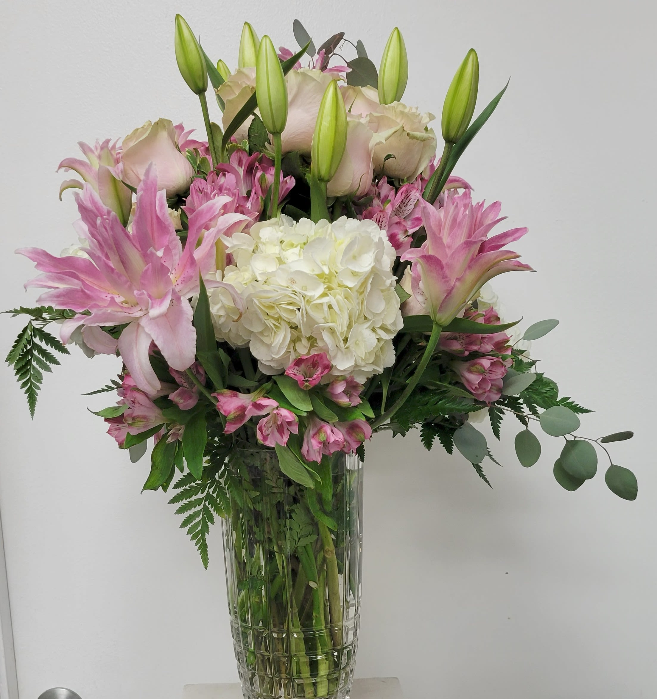 Pink lilies and white hydrangea in a clear glass vase