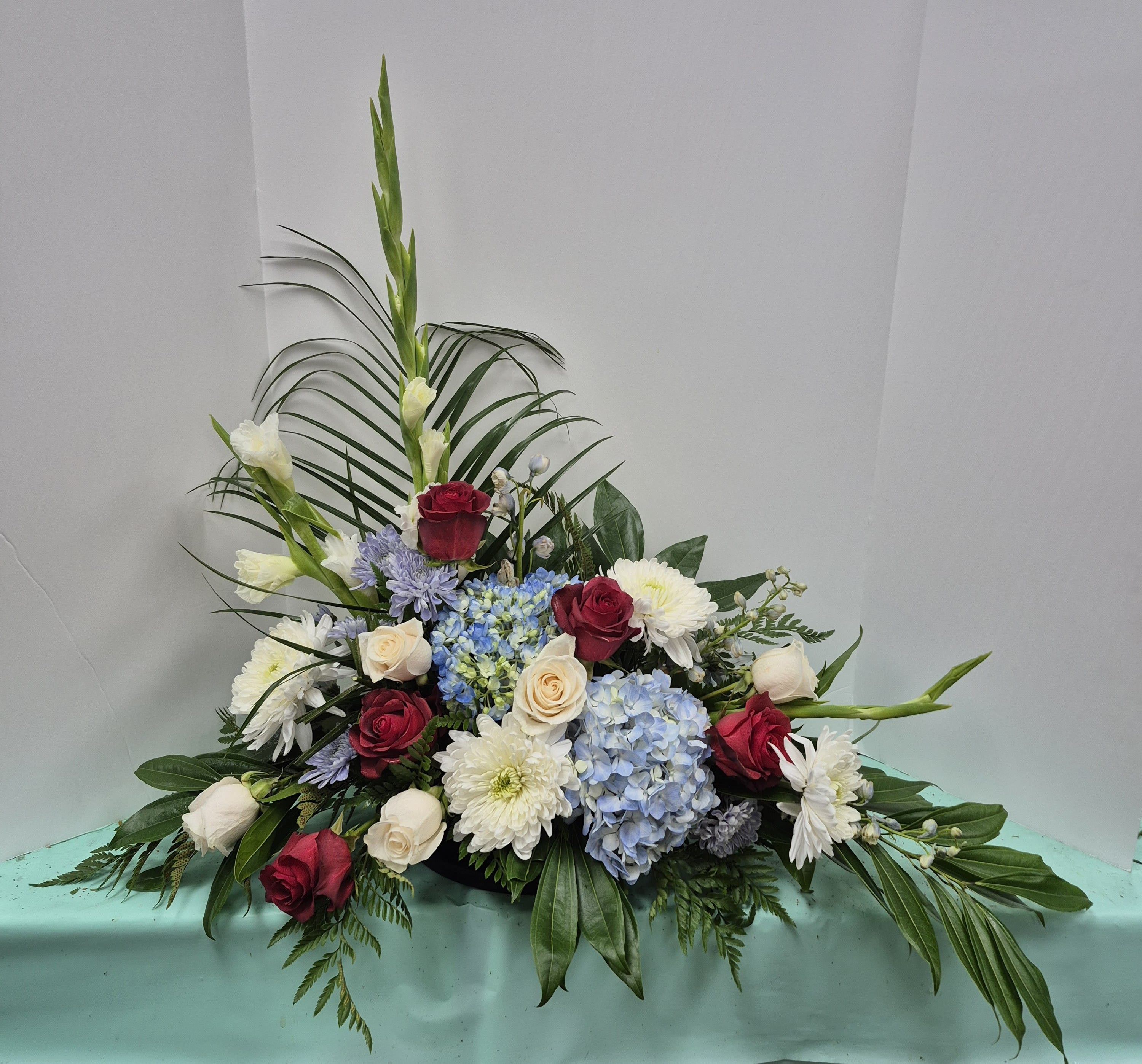 Low floral arrangement with roses, hydrangeas, and white blooms