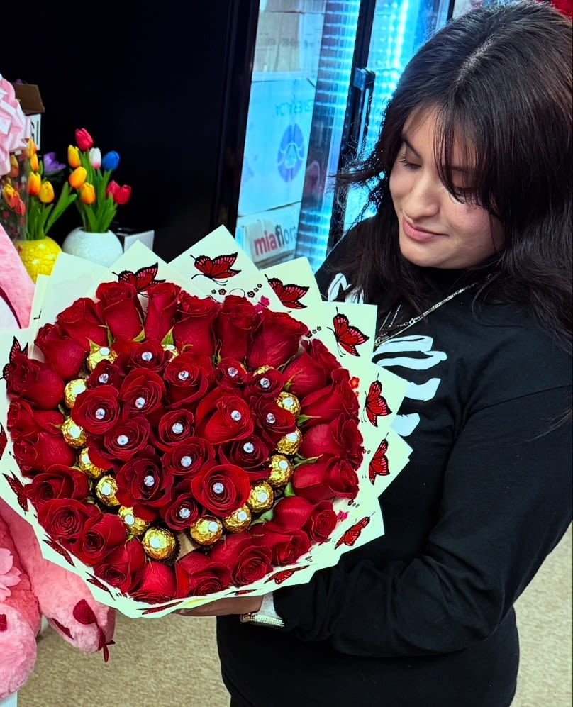 Heart-shaped bouquet of red roses with gold chocolates and butterfly wrap