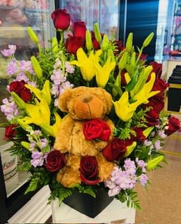 Bouquet of red roses and yellow lilies with a teddy bear