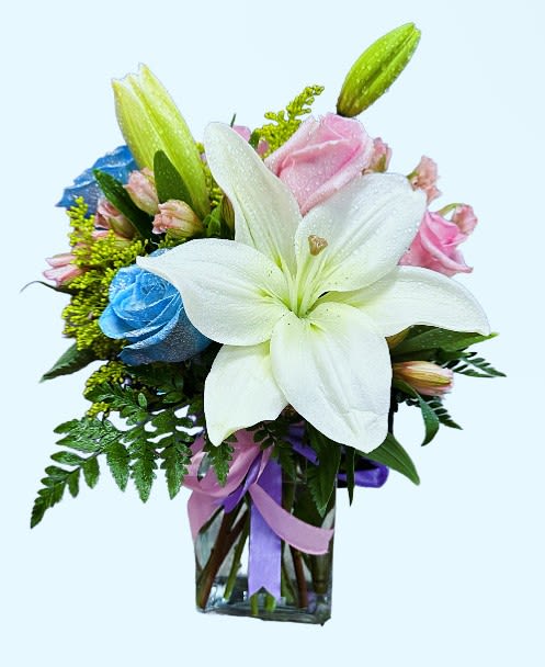 Bouquet of white lilies and pink roses in a glass vase with ribbon