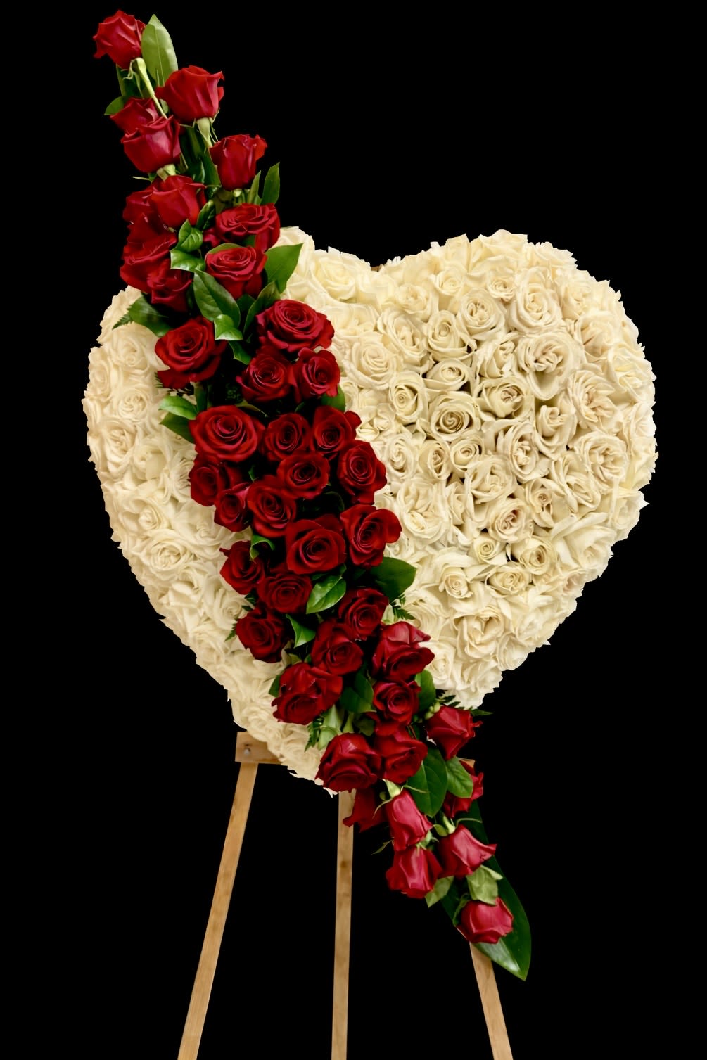 Heart-shaped rose arrangement with a red rose cascade on an easel