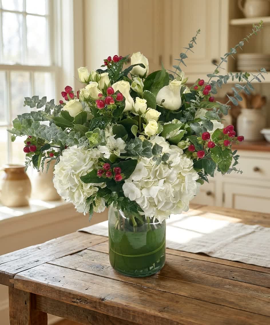 Winter Forest (DL) - A fresh, softly rustic take on seasonal elegance, this flower arrangement pairs lush white hydrangeas and cream-to-white roses for a full, rounded bouquet ideal as a winter centerpiece or a thoughtful sympathy arrangement. The clear glass vase keeps the look bright and modern while small red berry accents and airy eucalyptus-like branches weave movement and a touch of holiday warmth-perfect for sending as a cozy birthday gift, holiday surprise, or simple "thinking of you" bouquet. 