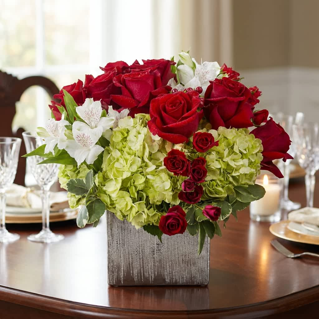 Winter Romance (DL) - Deep, romantic red roses paired with pale green hydrangeas and crisp white alstroemeria create a classic winter centerpiece built to make someone feel celebrated-perfect as a dining table arrangement for an anniversary, wedding reception, or intimate holiday dinner. This flower arrangement balances bold color and soft texture so the person you're thinking of will see both elegance and warmth the moment it arrives.  