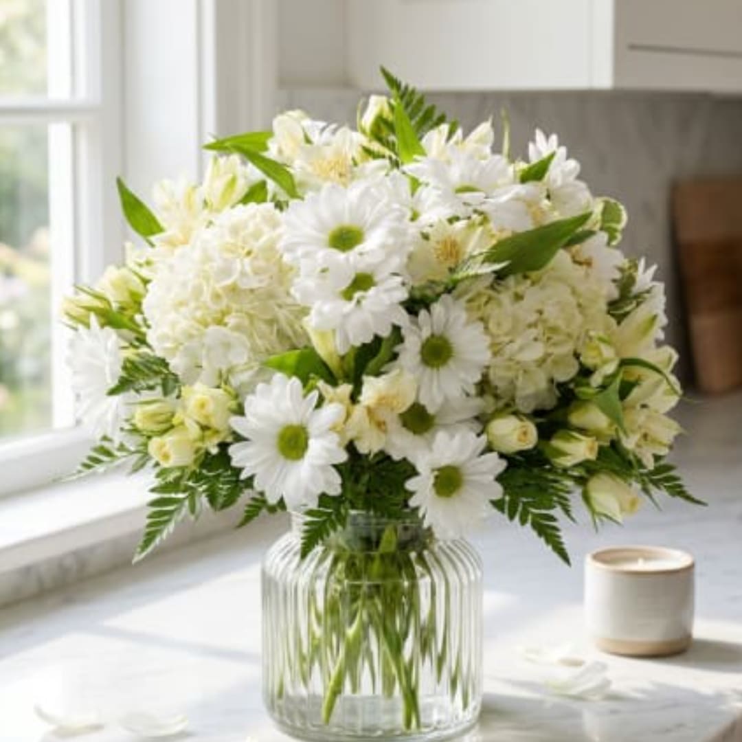 White daisy and hydrangea bouquet in a clear glass vase