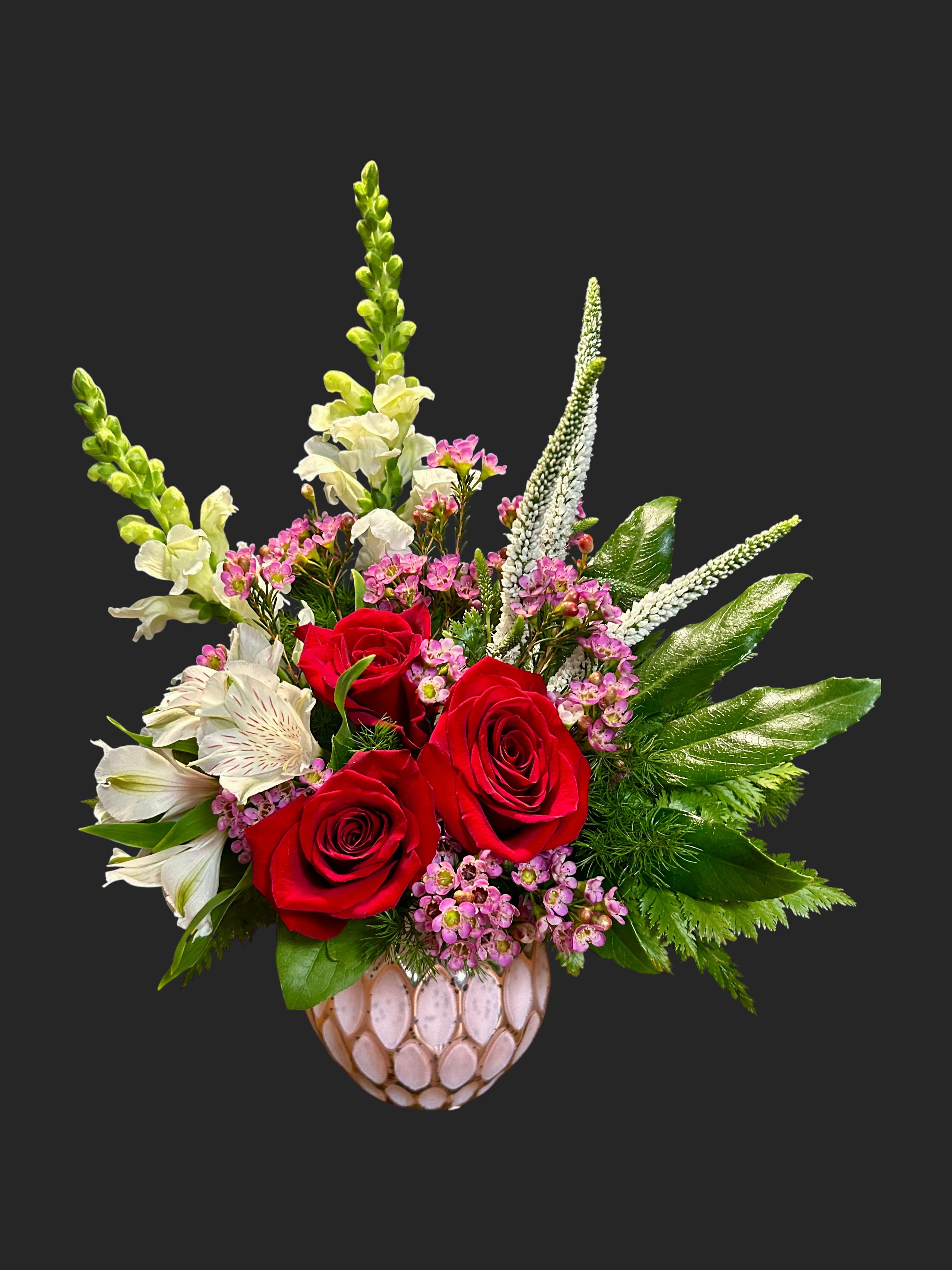 Red roses and white snapdragons in a decorative vase