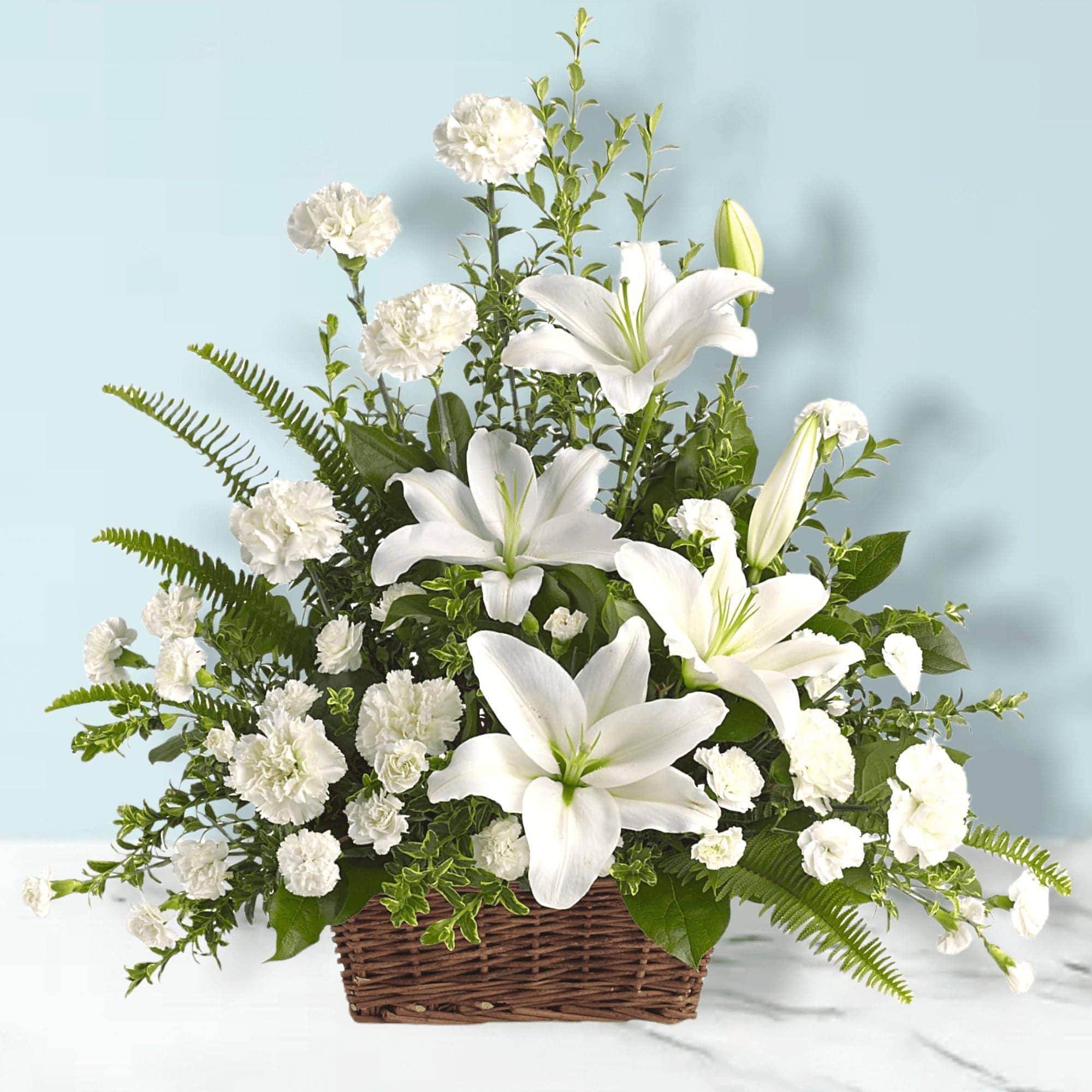 White lilies and carnations in a wicker basket
