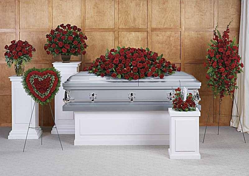 Red rose funeral casket spray with standing floral tributes