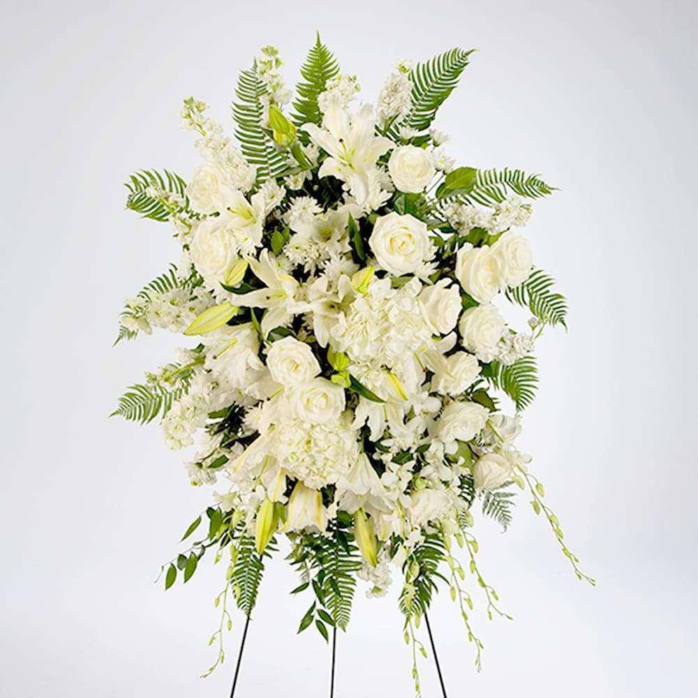 White floral standing spray with roses and lilies on a stand