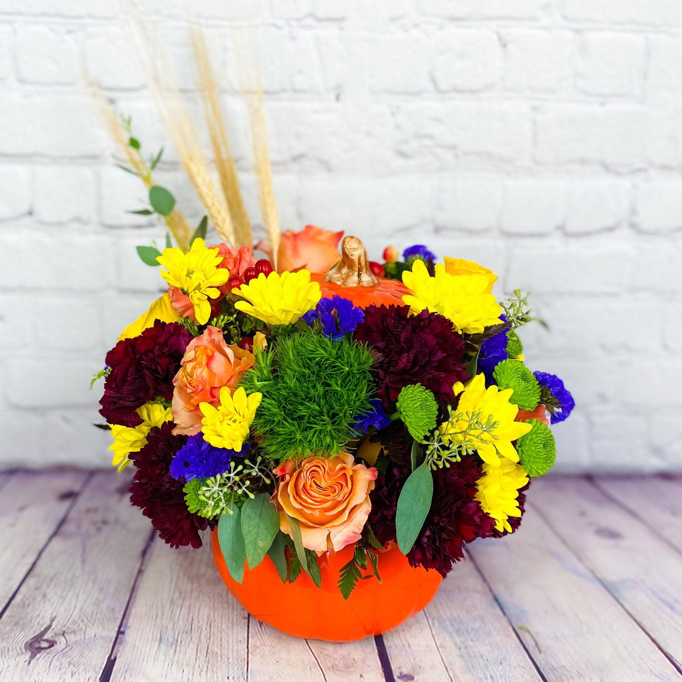 Fall Pumpkin Surprise - Nothing says Fall like pumpkins, so brighten someone's day with our Fall Pumpkin Surprise bouquet. This pumpkin, filled with orange roses and burgundy carnations mix with yellow daisies and green poms is the perfect decoration for fall!   --   Nothing says Fall like pumpkins, so brighten someone's day with our Fall Pumpkin Surprise bouquet. This pumpkin, filled with orange roses and burgundy carnations mix with yellow daisies and green poms is the perfect decoration for fall! Delivered in a ceramic pumpkin container, this bouquet is the perfect gift for Halloween or the fall season.  Includes:      Burgundy Carnations     Orange Roses     Yellow Daisies     Green Poms     Ceramic Pumpkin Container   