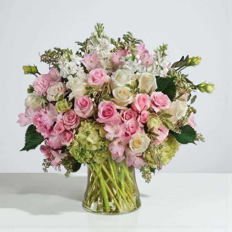Pink and white rose bouquet in a clear glass vase
