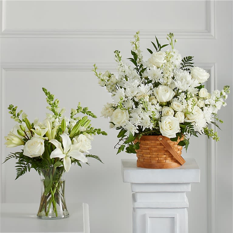 White floral arrangements in a glass vase and wicker basket