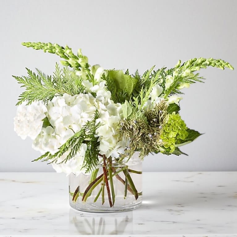 White and green floral arrangement in a clear glass vase