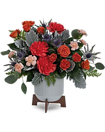 Teleflora's Retro Brights Bouquet - Sure to brighten their day, Teleflora's Retro Brights Bouquet of radiant orange blooms looks sleek in a matte ceramic planter with retro-inspired wooden base. Orange spray roses, orange carnations, miniature peach carnations, blue eryngium and dusty miller are accented with silver dollar eucalyptus and leatherleaf fern. Delivered in a Classic Contemporary planter.