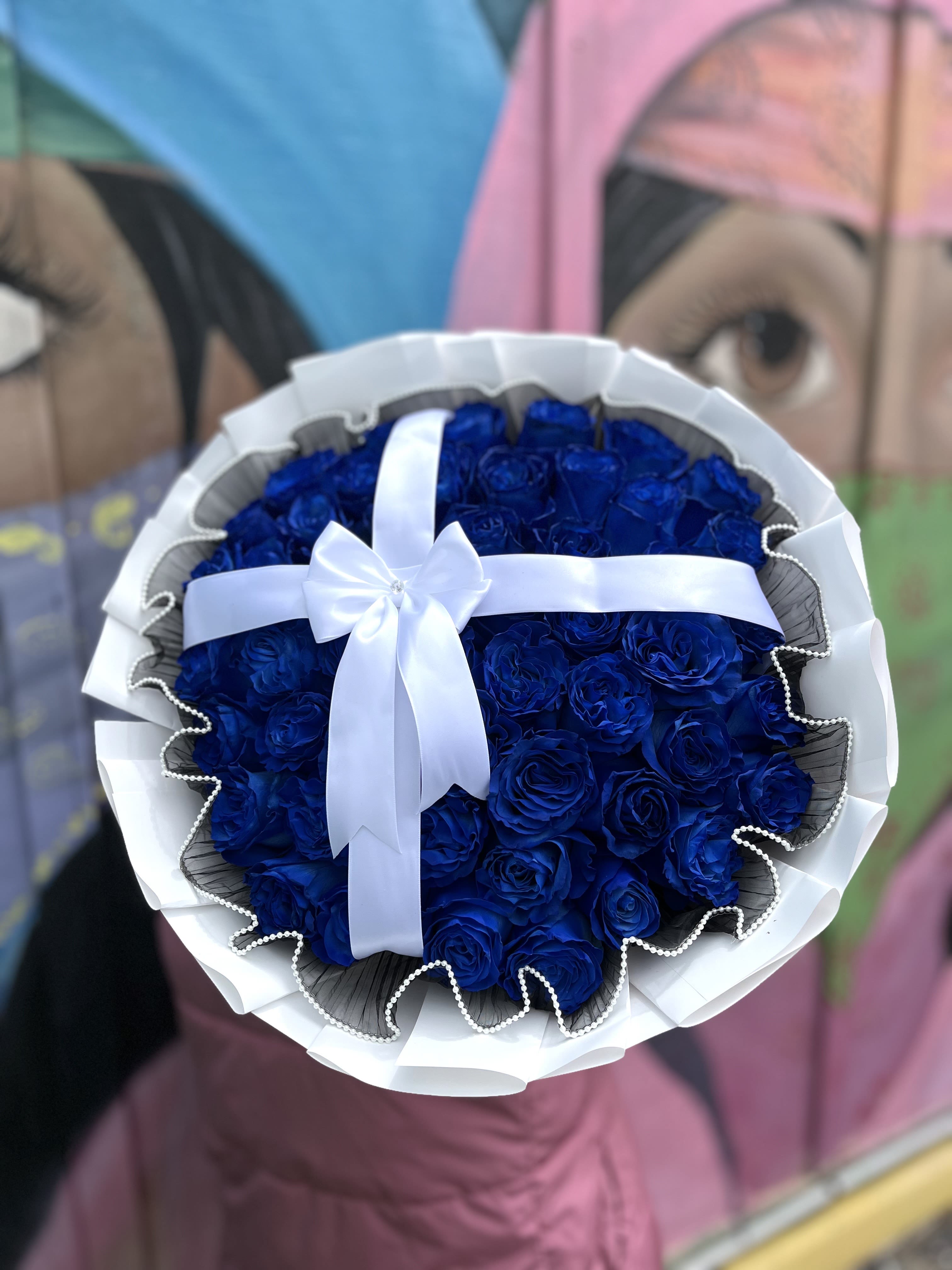 Bouquet of deep blue roses wrapped with white ribbon