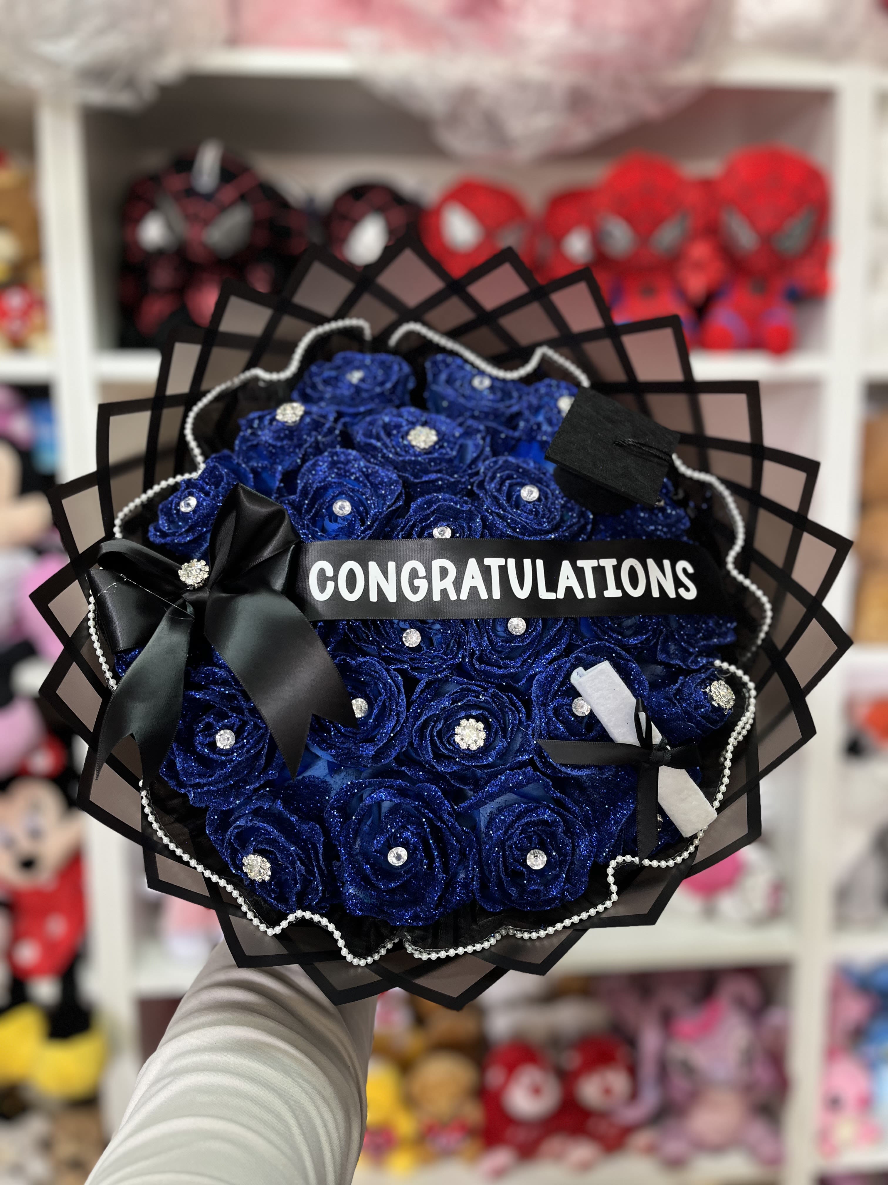 Blue rose bouquet with a congratulations ribbon and black wrapping