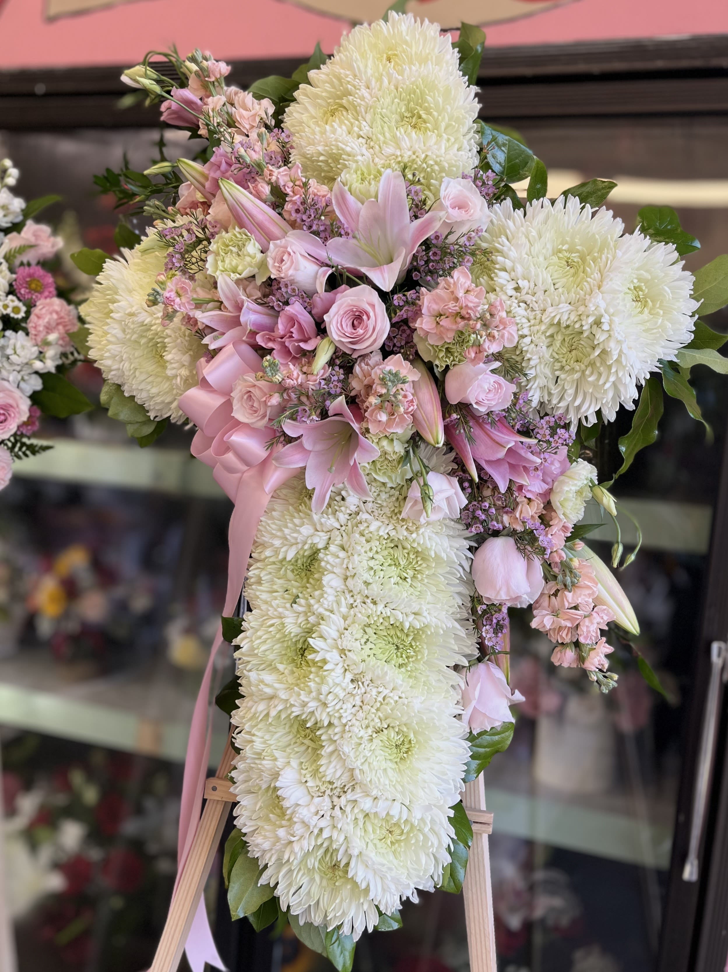 Pink and white floral standing spray with ribbon on an easel