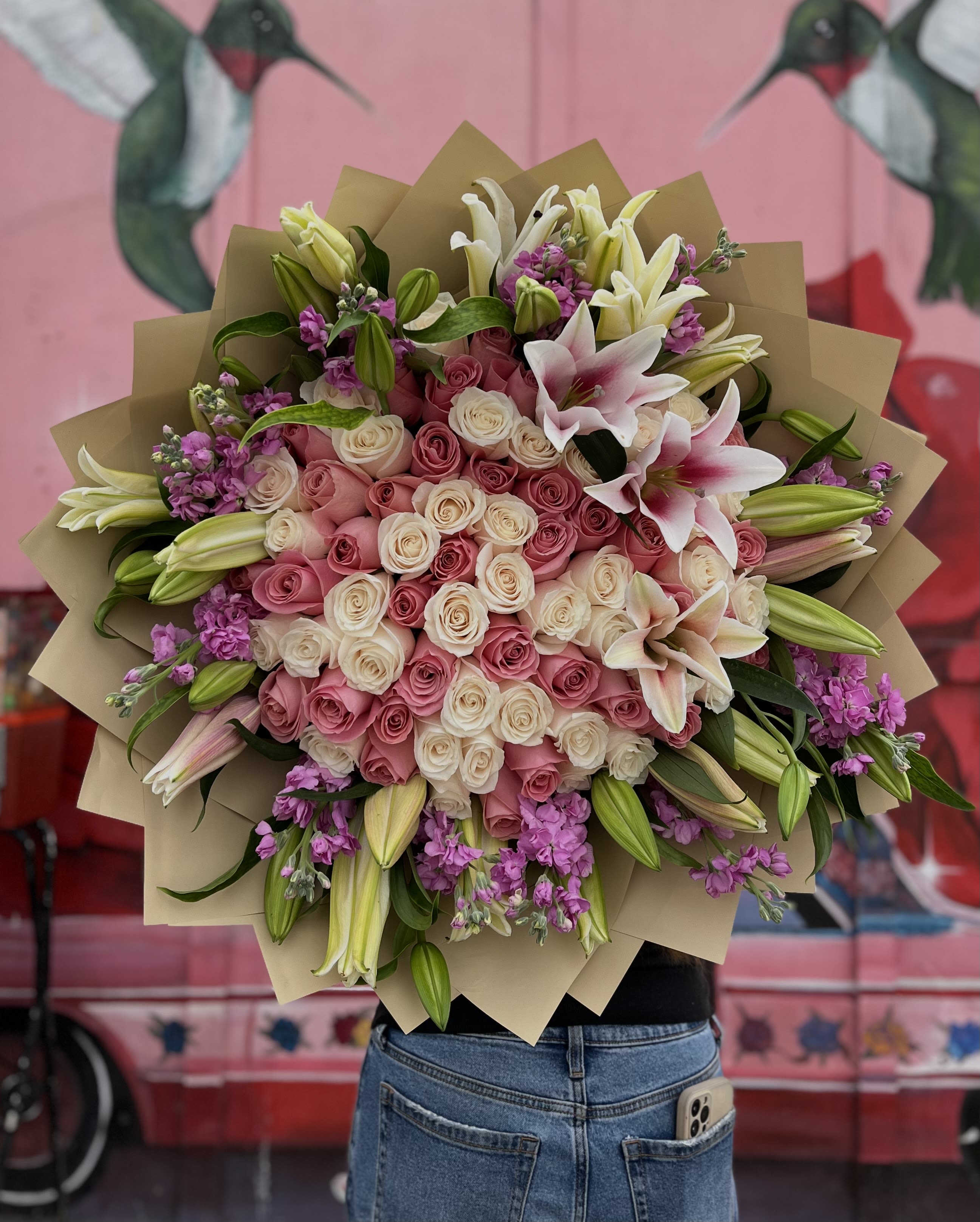 Large bouquet of pink and white roses with lilies and purple filler flowers