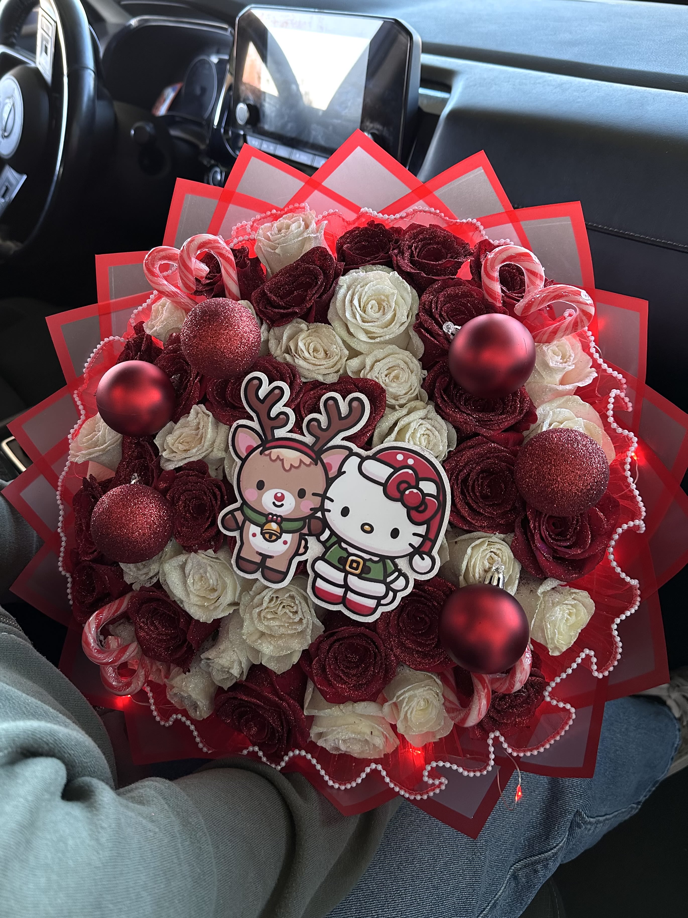 Bouquet of red and white roses with holiday ornaments and cartoon toppers