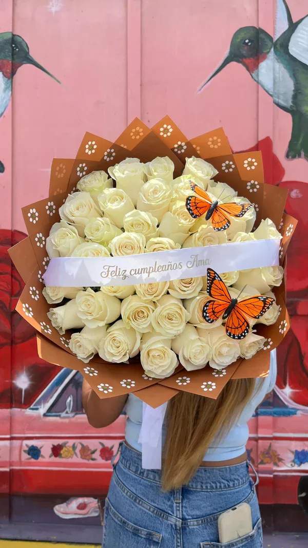 Bouquet of cream roses wrapped in brown paper with butterfly decorations