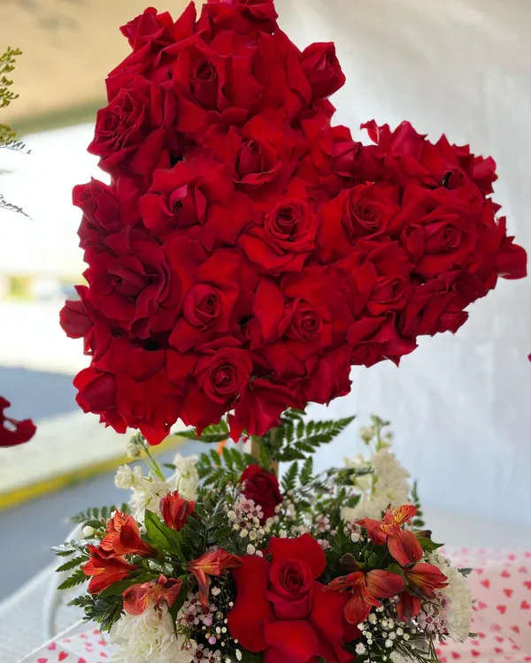 Heart-shaped red rose arrangement above a mixed red and white floral bouquet