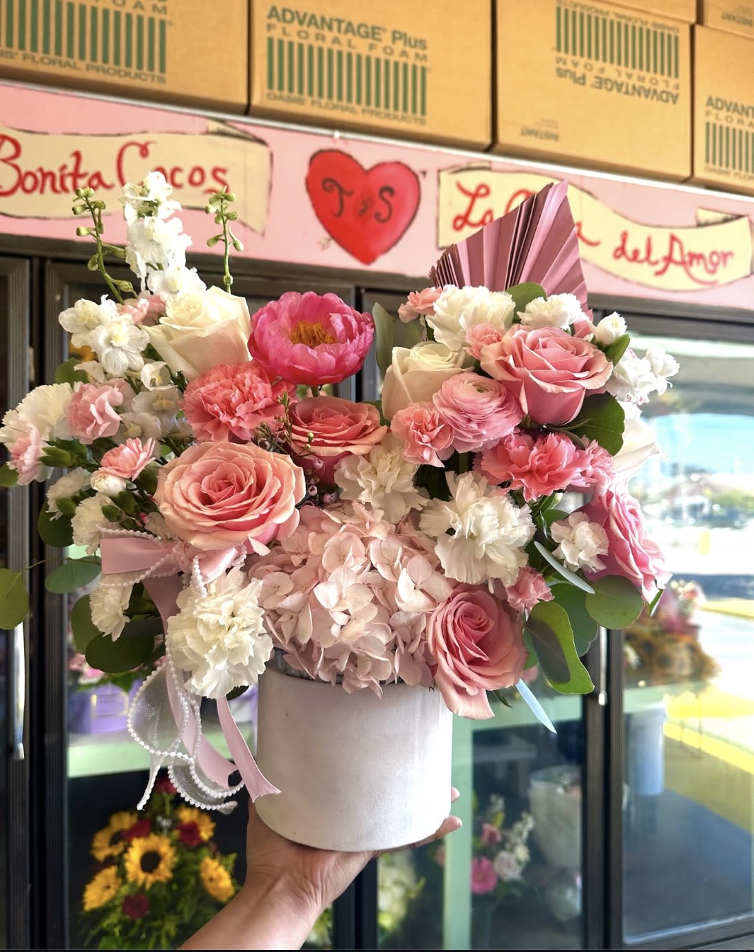 Pink and white floral arrangement in a white hat box