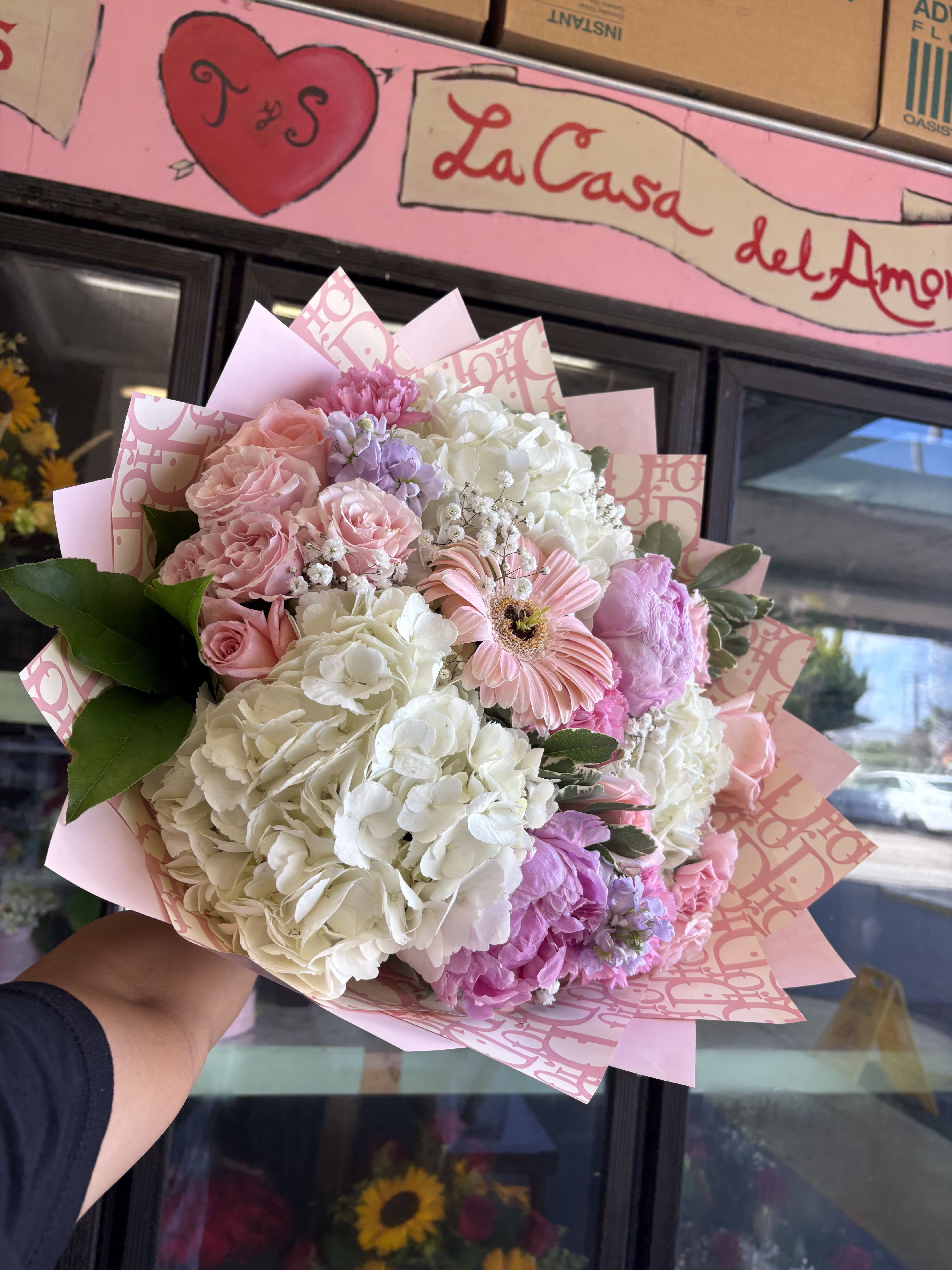Pink and white mixed bouquet with roses and hydrangeas in decorative wrap