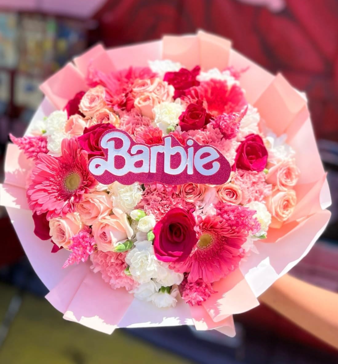 Pink and white bouquet with a Barbie sign