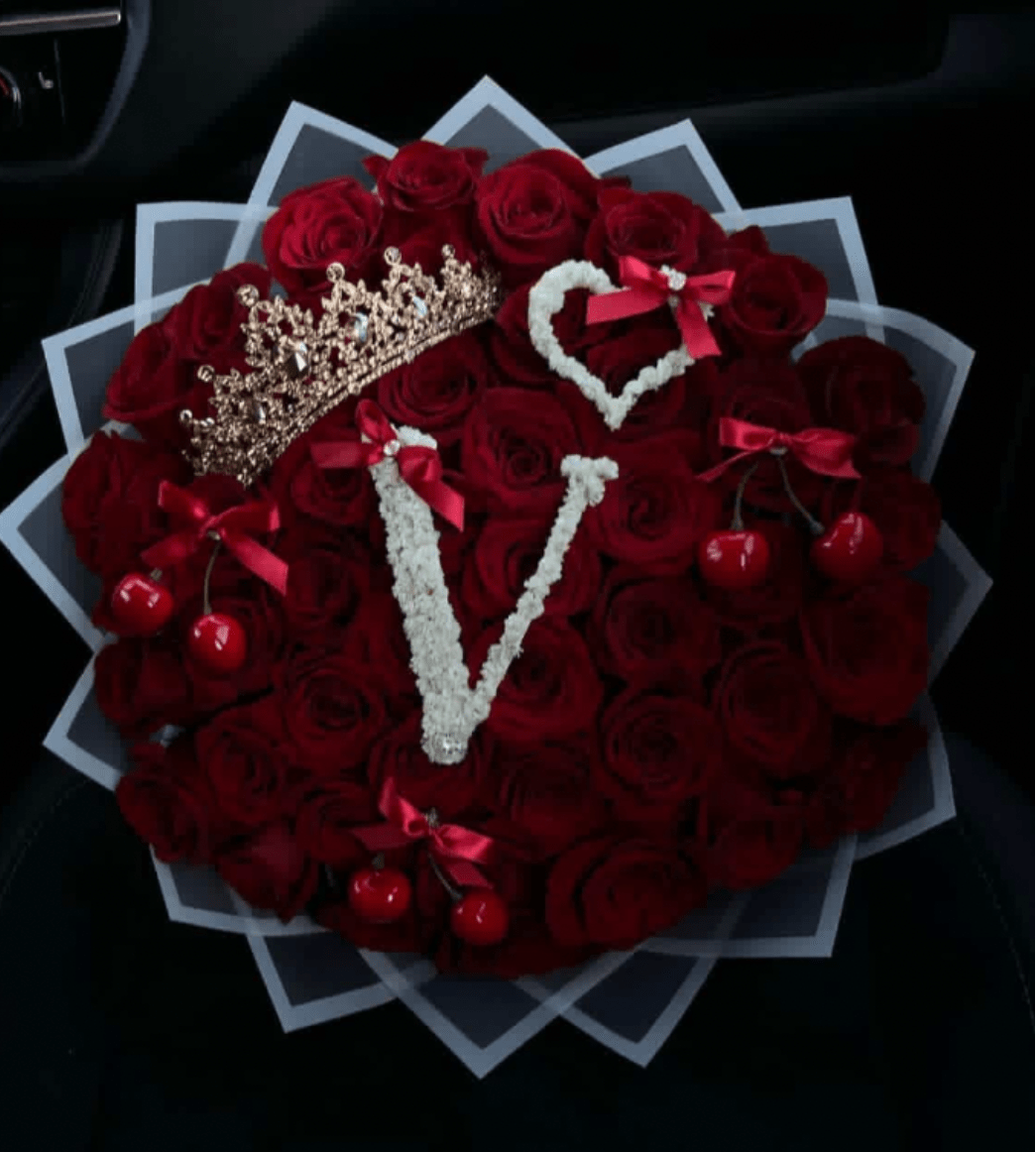 Heart-shaped bouquet of red roses with decorative crowns and cherries