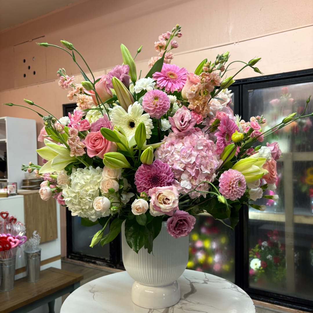 Pink and white mixed flower arrangement in a white vase