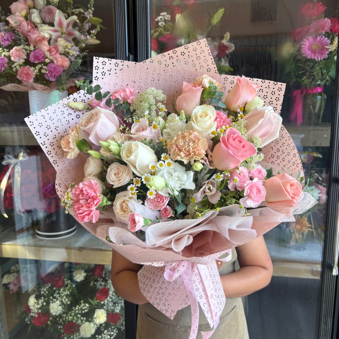 Large bouquet of pink and cream roses with carnations and small white daisies