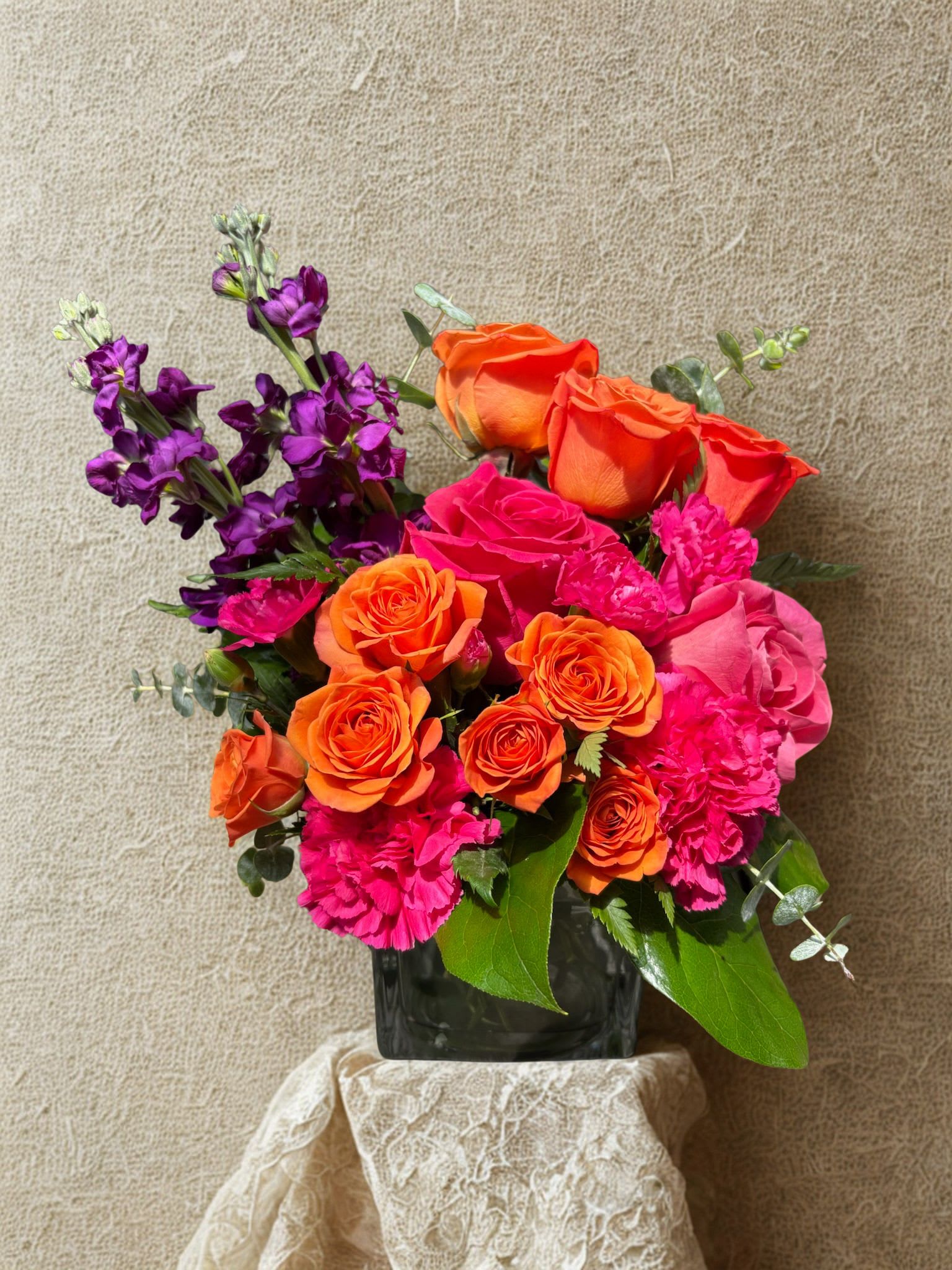 Orange You glad  - A bold burst of color-this birthday bouquet blends vivid orange and hot pink roses with bright gerbera daisies and magenta carnations to create an energetic, celebratory statement. Designed for birthdays, congratulations, or a romantic surprise, the compact rounded shape reads joyful and confident so the person you're sending it to will feel noticed and genuinely cheered.  This is the kind of bouquet that announces celebration-perfect for a milestone, a "thinking of you" moment, or to say "congratulations" with color. Water daily and keep away from direct heat; choose your vase preference at checkout to fit the recipient's style.