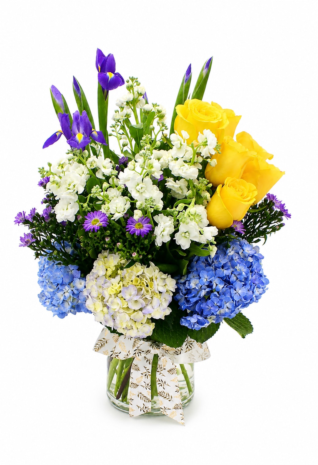 Grand Bloom Cylinder Garden  -  Overflowing with additional premium yellow roses, elegant purple irises, lush blue hydrangeas, soft white blooms, and enhanced seasonal accents, this fuller design is expertly handcrafted in a large 6-inch glass cylinder vase. Rich textures, vibrant colors, and abundant greenery create a stunning garden-inspired display that radiates sophistication from every angle. Perfect for milestone birthdays, anniversaries, corporate gifts, grand celebrations, or any occasion that calls for an unforgettable floral statement.