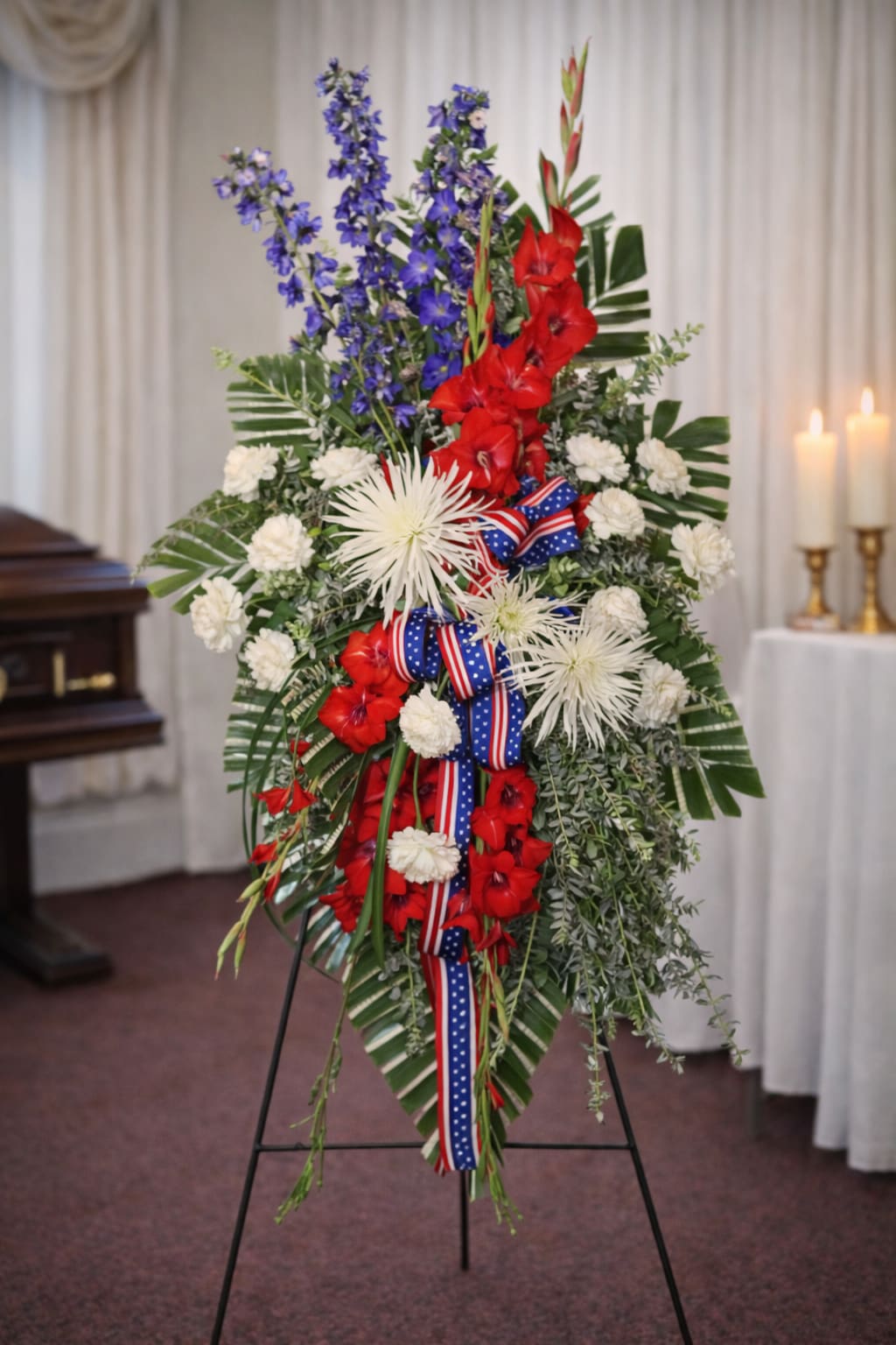 Standing floral spray with red, white, and blue flowers on an easel