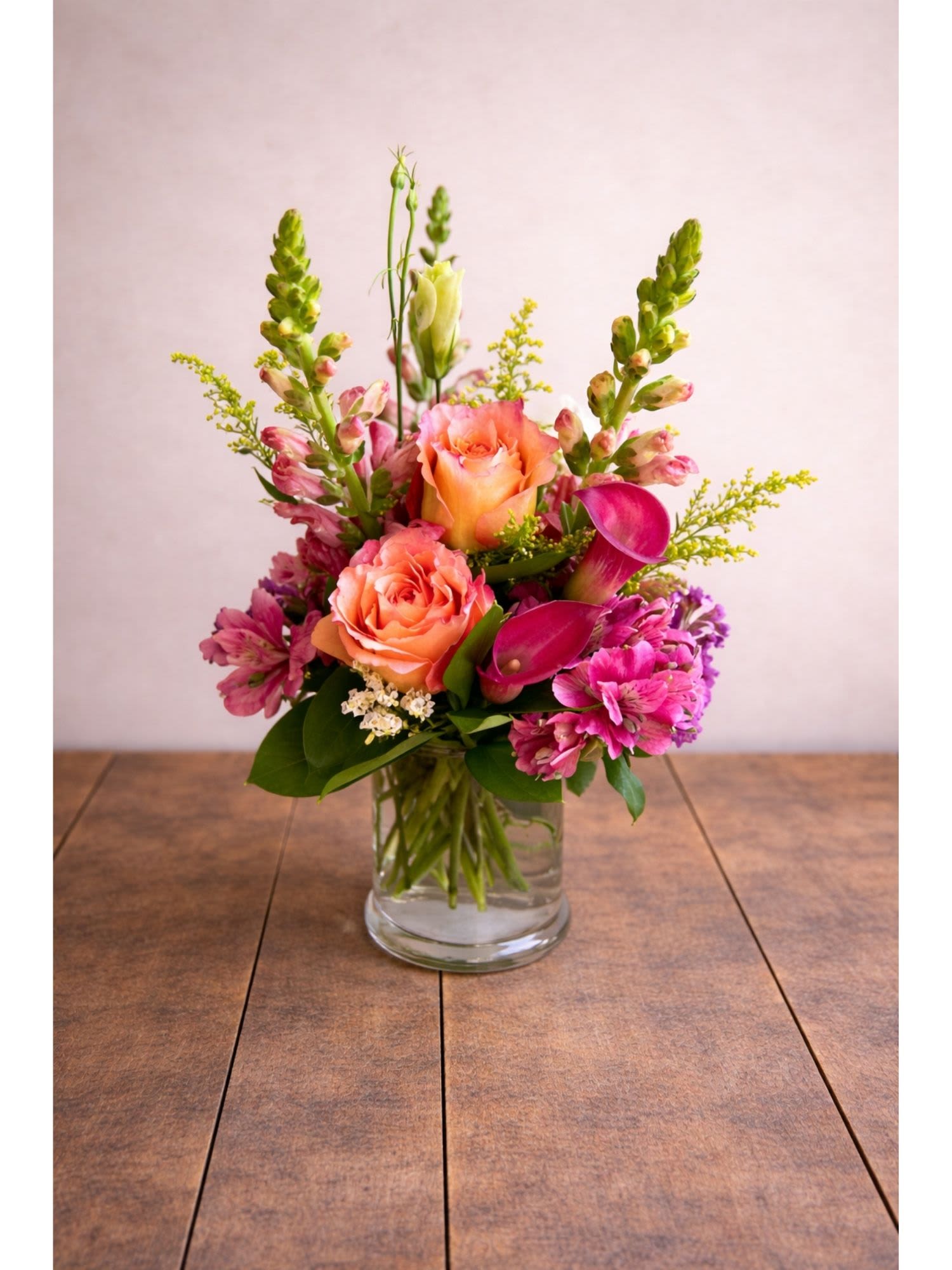 Sorbet Dreams  - A pink rose and calla lily vase arrangement available for same-day flower delivery in Round Rock, TX beautiful arrangement of coral and lavender flowers, adding a touch of color and charm to any room.  The delicate flowers are expertly arranged to create a stunning visual display, making it a perfect personal floral design for any end table or nightstand. Whether used as a standalone decorative piece or as part of a larger floral arrangement, this vase is sure to add a touch of elegance to any space.