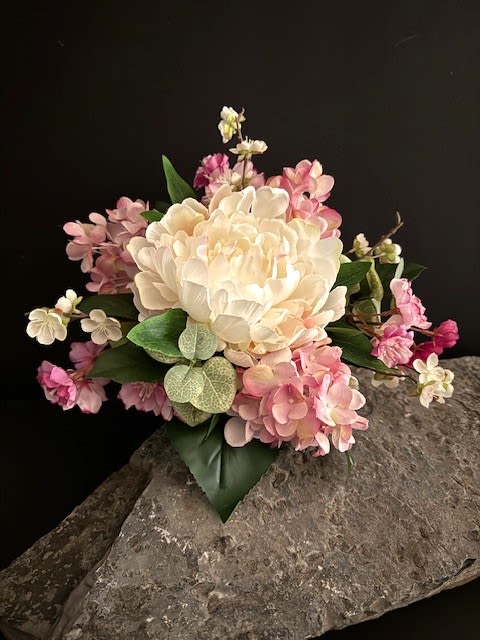 #A080 - White Peony &amp; Pink Hydrangea Silk Floral Bouquet - A large ivory peony-style bloom anchors this silk wedding bouquet, its smooth petals surrounded by clouds of soft pink hydrangea-like clusters and creamy filler blossoms for a timeless, romantic look. As a wedding bouquet or centerpiece, the white peony and blush hydrangea palette reads classic and celebratory-perfect for a bride seeking an elegant, photographed-ready arrangement or for use as sweetheart table decor.  Crafted from high-quality silk, the piece keeps a polished, enduring shape with broad green leaves and patterned faux foliage adding natural contrast to the pastels. Choose the hand-tied option wrapped in white satin with neat pearl accents for a refined bridal carry, or the fluted clear glass vase set on a large flat stone slab to introduce gentle texture and weight to centerpieces. The compact, domed silhouette measures as a full, garden-inspired bouquet while remaining tidy for easy handling.  Ideal for weddings, anniversaries, or any romantic celebration, this arrangement gives the person you love a lasting keepsake that looks fresh day after day without wilting. Available in bridal hand-tied or vase presentation-note the satin-wrapped stem and pearl finish on the bouquet version for classic bridal styling-and simple care involves gentle dusting to preserve the silk's soft sheen.  Shipping available - select Delivery, then message us to ship.