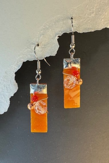 #A014 - Bright Orange Stained Glass Earrings - Glossy rectangular orange pendants catch the light in these handmade dangle earrings, a bright, modern accessory perfect as a Mother's Day gift or a cheerful birthday surprise. The warm orange and red tones read joyful and confident-an ideal little something to celebrate an anniversary, graduation, or to say "thinking of you" with a pop of color.  Each earring hangs from a simple silver-tone hook and is finished with a silver cap, fine wire wrapping, a clear faceted bead, a small red bead, and a metallic accent bead for subtle sparkle. Lightweight and easy to wear, they pair beautifully with casual spring and summer looks or add a playful accent for holiday and winter outfits-great for prom, bridesmaid extras, or a "just because" present to make someone feel truly seen.  Presented as a handcrafted pair, these earrings slot neatly alongside floral gifts for occasions like Valentine's Day, Thank You gestures, Get Well wishes, or an "I'm Sorry" olive branch. Their versatile style suits recipients who favor handmade details and bright color; treat the person you're thinking of to a wearable keepsake that feels personal and joyful.  Shipping available - select Delivery, then message us to ship.
