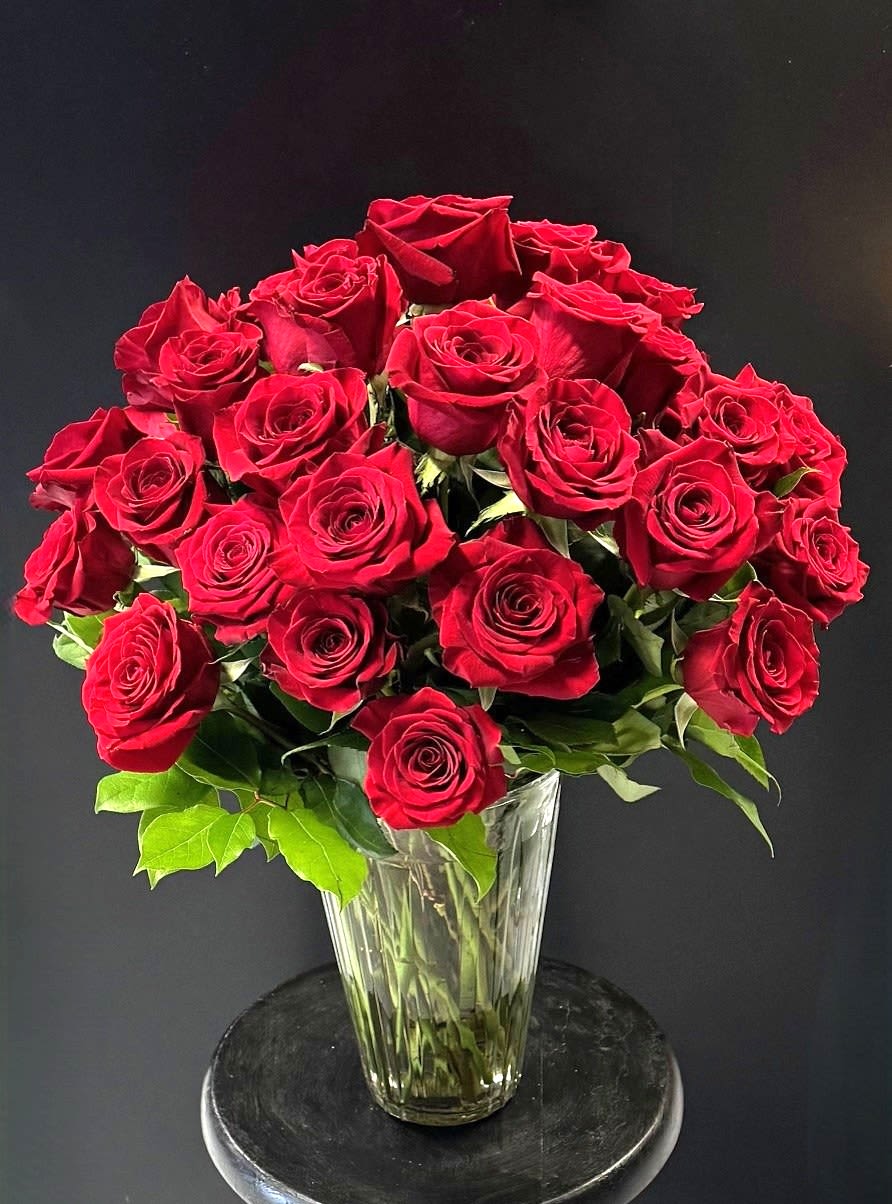 #A033 - Going All Out! - Want to make a huge statement?  This is a great way to do it!  We combine 24 gorgeous red roses and greens in a vase that will make everyone jealous!  Also available in other colors, depending on availability.  Call us for more information at 540-810-2161 or 540-820-1509.